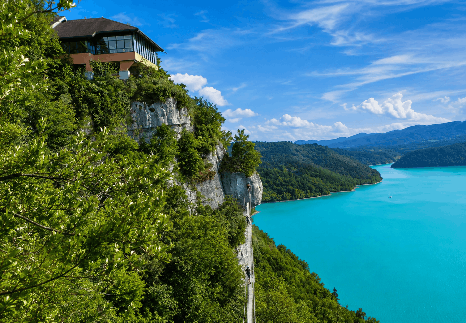 Via ferrata du Regardoir sur les falaises dominant les eaux turquoise du lac de Vouglans dans le Jura.