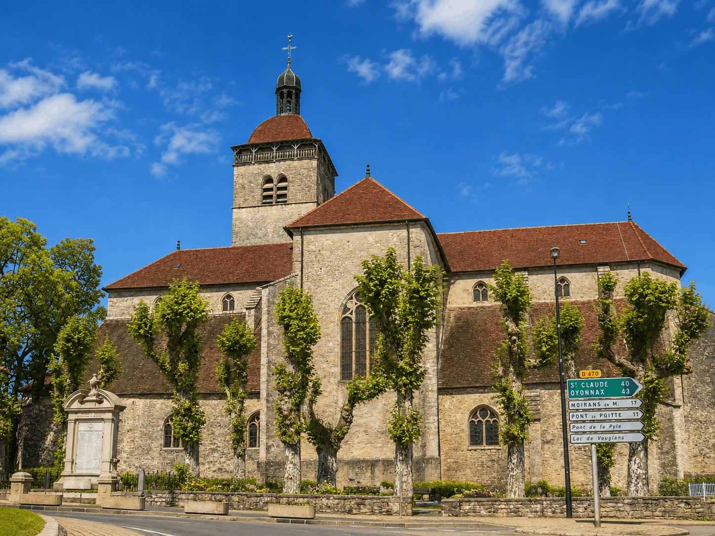 Église Notre-Dame d’Orgelet sous un ciel bleu en été, au cœur du Jura.